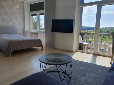 a bedroom with a bed and a table and a tv at Kaunas Center Apartments - K. Mindaugo g. in Kaunas