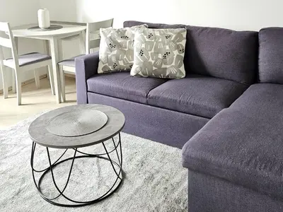 a purple couch with a table in a living room at Kaunas Center Apartments - K. Mindaugo g. in Kaunas