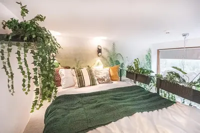 a bedroom with a bed with plants on the wall at Jungle in Vilnius City Center by URBAN RENT in Vilnius