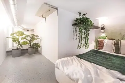 a bedroom with a bed and potted plants in it at Jungle in Vilnius City Center by URBAN RENT in Vilnius