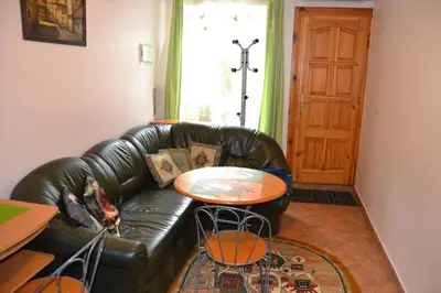 a living room with a leather couch and a table at Danarent Apartment in Vilnius