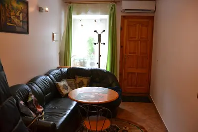 a living room with a black leather couch and a table at Danarent Apartment in Vilnius