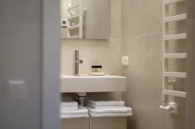 a bathroom with a white sink and towels at The Elegant Escape in Šiauliai