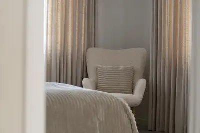 a white chair with a pillow in a bedroom at The Elegant Escape in Šiauliai