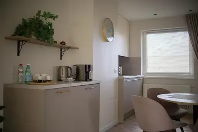 a kitchen with white cabinets and a table and a window at The Elegant Escape in Šiauliai