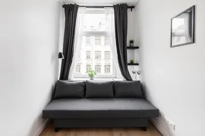 a couch in a room with a window at Hook Studios Vilnius Old Town Economy in Vilnius