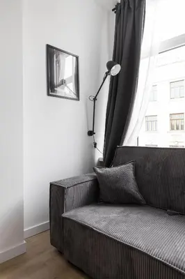 a couch in a living room with a window at Hook Studios Vilnius Old Town Economy in Vilnius