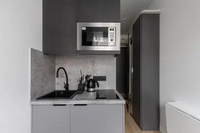 a kitchen with a sink and a microwave at Hook Studios Vilnius Old Town Economy in Vilnius