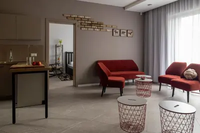 a living room with red chairs and a table at Sabos Rezidencija Private Countryside Villa near Vilnius in Dzenkuniskes
