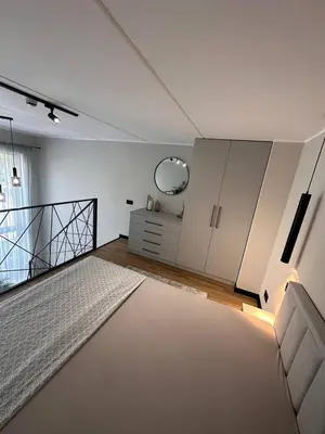 a white bedroom with a bed and a mirror at Sunny loft 24x7 x free parking x close to old town by H&H in Vilnius