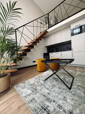 a room with a table and chairs and a staircase at Sunny loft 24x7 x free parking x close to old town by H&H in Vilnius