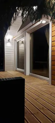 a deck with two large windows on a house at Sodyba Narūnas VIP namelis in Sponėnai