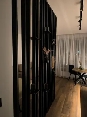 a room with a black partition with a table at Ozo Parko Butas in Vilnius