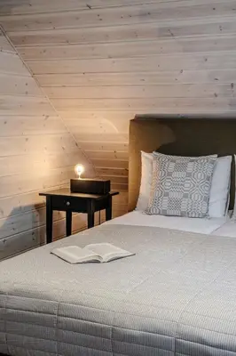 a bedroom with a bed with a book on it at Gamtos pinklės in Žiūrai