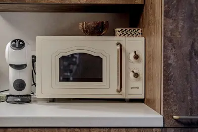 a microwave oven sitting on a shelf in a kitchen at Gamtos pinklės in Žiūrai