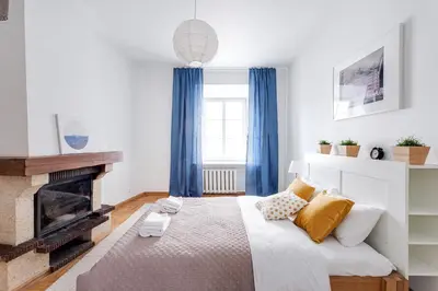 a bedroom with a bed and a fireplace at Cosy and bright Saint Ignoto Apartment by Reside Baltic in Vilnius