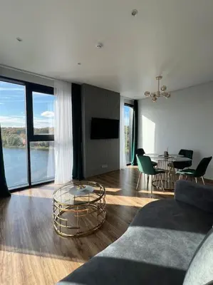 a living room with a couch and a table at Kaunorama apartamentai prie Žalgirio arenos in Kaunas
