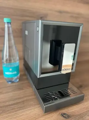 a small microwave and a bottle of water on a table at Kaunorama apartamentai prie Žalgirio arenos in Kaunas