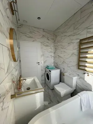 a white bathroom with a toilet and a sink at Kaunorama apartamentai prie Žalgirio arenos in Kaunas