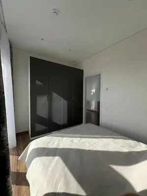 a bedroom with a large bed with black cabinets at Kaunorama apartamentai prie Žalgirio arenos in Kaunas
