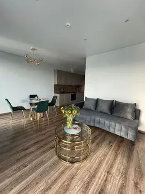 a living room with a couch and a table at Kaunorama apartamentai prie Žalgirio arenos in Kaunas