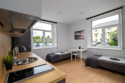 a kitchen and living room with two beds and a sink at Restart in Kaunas