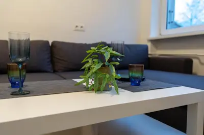 a table with two glasses and a plant on it at Urban Studio Vilnius in Vilnius