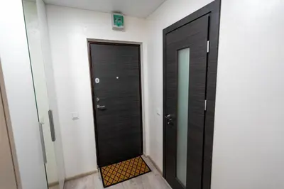 a hallway with a black door and a mirror at Urban Studio Vilnius in Vilnius