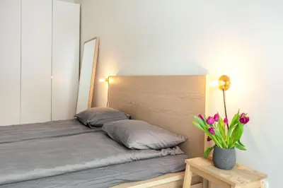 a bed with two pillows and a vase with flowers at Angel House Vilnius 37 in Vilnius