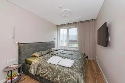 a bedroom with a bed with two towels on it at Birstonas Rent in Birštonas