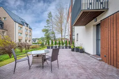 a patio with a table and chairs and buildings at Birstonas Rent in Birštonas
