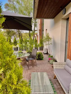 a patio with a table and chairs and an umbrella at Birstonas Rent in Birštonas