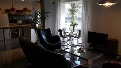 a living room with a glass table and black chairs at Vilnius Luxury Apartment 1 in Vilnius
