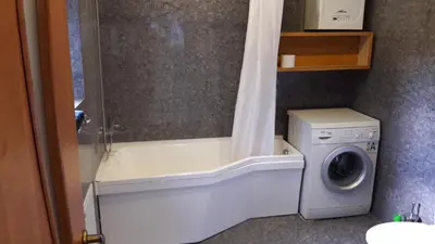 a bathroom with a washing machine and a bath tub at Vilnius Luxury Apartment 1 in Vilnius
