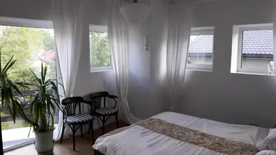 a bedroom with a bed and two chairs and windows at Vilnius Luxury Apartment 1 in Vilnius