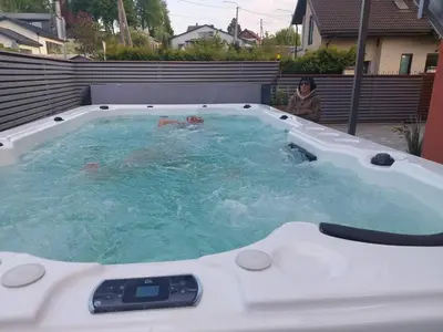 a person in a jacuzzi bathtub with a woman in it at Villa SPA in Vilnius