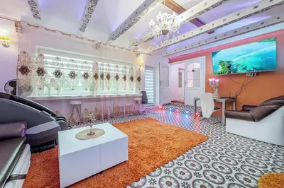 a living room with pink walls and a chandelier at Villa SPA in Vilnius