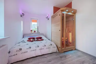 a bedroom with a bed and a wooden cabinet at Villa SPA in Vilnius