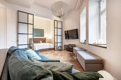 a living room with a couch and a bedroom at Boutique apartment in Old Town in Vilnius