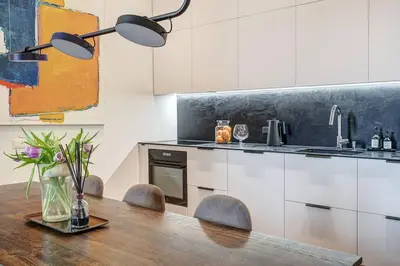 a kitchen with a wooden table with chairs and a counter at Boutique apartment in Old Town in Vilnius