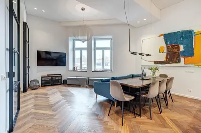 a living room with a table and chairs and a couch at Boutique apartment in Old Town in Vilnius