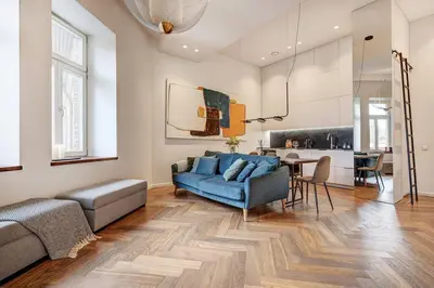 a living room with a blue couch and a table at Boutique apartment in Old Town in Vilnius