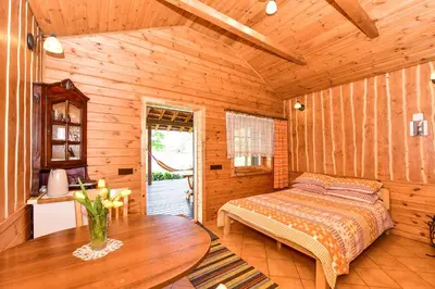 a bedroom with a bed and a table in a room at Sodyba Pas Drambliuka in Svėdasai