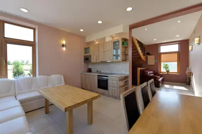 a kitchen and living room with a table and a couch at Sodyba Pas Drambliuka in Svėdasai