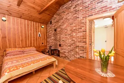 a bedroom with a bed and a table and a brick wall at Sodyba Pas Drambliuka in Svėdasai