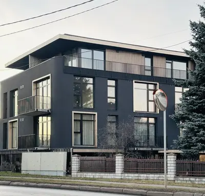 a black building with balconies and a street sign at Apartment near Hospital Kaunas Clinics in Kaunas