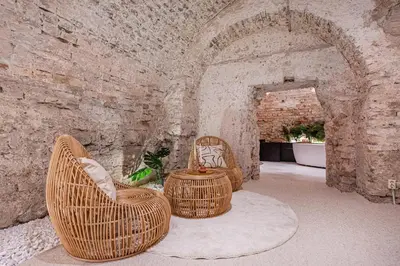 two wicker chairs and a table in a brick wall at Aura Spa in Vilnius