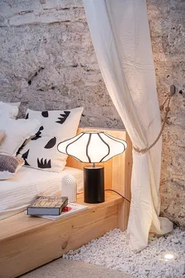 a lamp sitting on a table next to a bed at Aura Spa in Vilnius