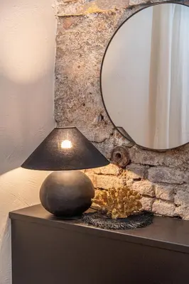a lamp on top of a table with a mirror at Aura Spa in Vilnius