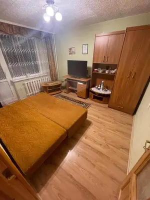 a bedroom with a bed and a desk and a television at Ground floor apartment close to city centre and tourist attractions in Druskininkai